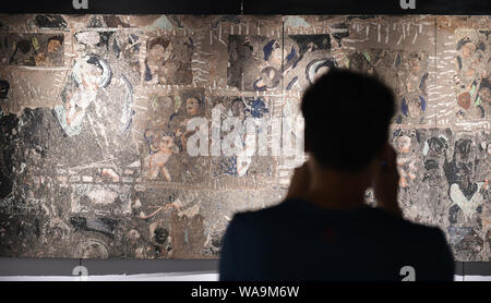 --FILE--i visitatori visualizzazione di una raccolta fotografica dei dipinti sulle pareti delle grotte Kizil conservati all'estero presso un museo in Luoyang city, centrale della Cina di Henan pr Foto Stock