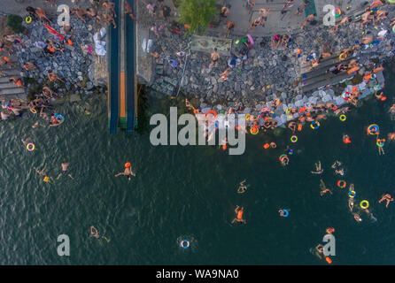 I residenti locali raccogliere e tuffarsi nel fiume Han raffreddare su un bruciante giorno in Xiangyang city, centrale cinese della provincia di Hubei, 22 luglio 2019. Foto Stock