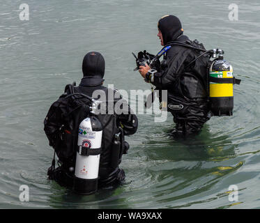 Subacquei o sub aqua divers in piedi in acqua Foto Stock