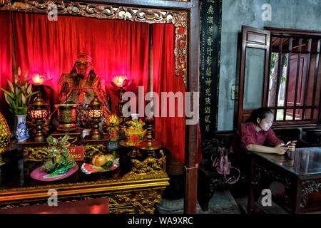 Hanoi, Vietnam - agosto 30: una donna che guarda al mobile in quan Thanh tempio su 30 Agosto 2018 ad Hanoi, Vietnam. Foto Stock