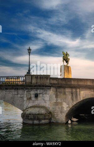 Zurigo la sera - parte del ponte Münsterbrücke con un lampione e due cigni sotto un ponte arch, dominata dal monumento equestre di Hans Waldmann (1435 - 6 Aprile 1489) Foto Stock
