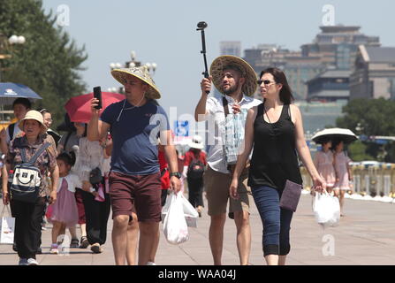 I turisti stranieri proteggersi con cappelli dal sole cocente alla Piazza Tian'anmen a Pechino, in Cina, il 3 luglio 2019. Un ondata di caldo colpirà chi Foto Stock