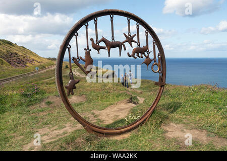 Walkers visto attraverso il fascino "braccialetto" Scultura dell'artista Richard Farrington sul modo di Cleveland Trail a Huntscliff vicino Cambs, Foto Stock