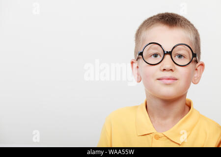 Ritratto di close-up di graziosi grave kid ragazzino nerd in bicchieri. Foto Stock