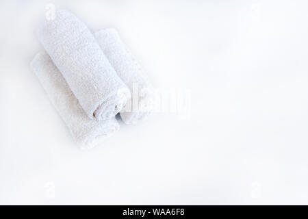White asciugamani puliti e Lavanda fiori bianchi su sfondo isolato. Foto Stock