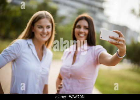 Happy business colleghi stanno prendendo selfie nel parco sulla rottura. Foto Stock