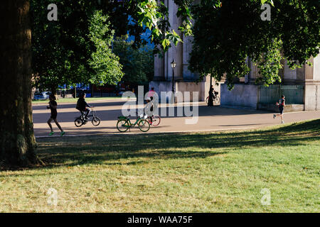 London, Regno Unito - 15 Luglio 2019: persone jogging e equitazione biciclette vicino a Wellington Arch vicino parco verde nel centro di Londra Foto Stock