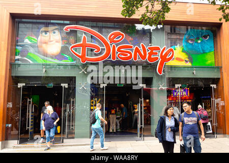 London, Regno Unito - 18 Luglio 2019: la gente a piedi nella parte anteriore del Disney store su Oxford Street, Londra. Oxford Street è una delle più famose strade per lo shopping Foto Stock