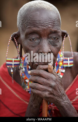 Vecchia donna Masai con tradizionale orecchini pone per un ritratto in Loitoktok, Kenya. Foto Stock