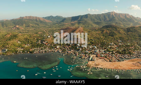 Vista aerea Coron città con le baraccopoli e di quartiere povero. Porta a mare, pier, cityscape Coron town con barche sull isola di Busuanga, Filippine, Palawan. Seascape con montagne. Foto Stock