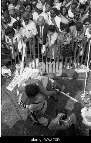 I diritti civili marzo su Washington, D.C.; inglese: fotografia mostra una folla di americani Africani dietro una tempesta recinto con la polizia che porta una donna su l'altro lato. Foto Stock