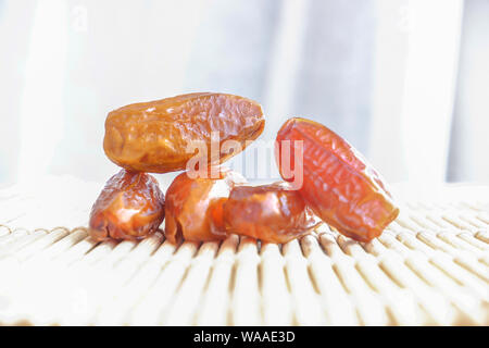 Gruppo di Phoenix di frutta sul tappetino di bambù, frutta secca data di Palm sul tappetino di bambù sfondo Foto Stock