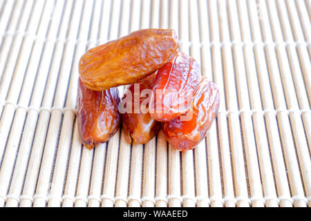 Gruppo di Phoenix di frutta sul tappetino di bambù, frutta secca data di Palm sul tappetino di bambù sfondo Foto Stock