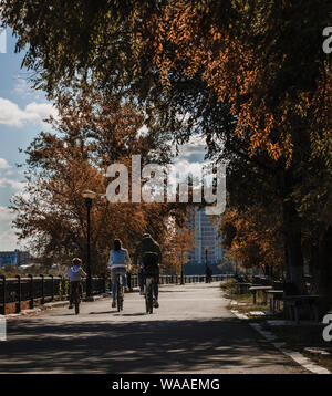 Famiglia su biciclette in autunno, escursioni in bicicletta all'aperto Foto Stock