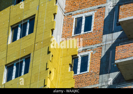 Ad alta altitudine lavorare sulle pareti esterne di isolante in lana di vetro e gesso Foto Stock