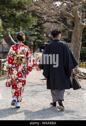 Una coppia Giapponese in kimonos cammina attraverso il Giardino Kenrokuen a Kanazawa, Giappone Foto Stock