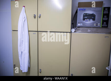 25 giugno 2019, Meclemburgo-Pomerania, Hohen Wangelin: un medico bianco del mantello e pende da una credenza nella sala pausa del medico di paese in pratica di 74-anno-vecchio Lothar Kruse. Il medico di medicina generale è stato il trattamento di pazienti provenienti dalla regione nella sua pratica in Hohen Wangelin per 40 anni. Alla fine del 2019, Kruse vuole dare la sua pratica, ma finora ha cercato senza successo un successore. Foto: Jens Büttner/dpa-Zentralbild/ZB Foto Stock