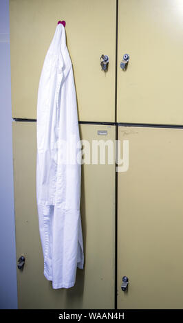 Hohen Wangelin, Germania. Il 25 giugno, 2019. Un medico bianco del mantello e pende da una credenza nella sala pausa del medico di paese in pratica di 74-anno-vecchio Lothar Kruse. Il medico di medicina generale è stato il trattamento di pazienti provenienti dalla regione nella sua pratica in Hohen Wangelin per 40 anni. Alla fine del 2019, Kruse vuole dare la sua pratica, ma finora ha cercato senza successo un successore. Credito: Jens Büttner/dpa-Zentralbild/ZB/dpa/Alamy Live News Foto Stock