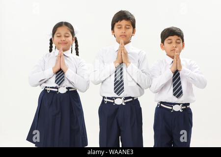 School children praying with hands joined together Stock Photo