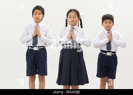 School children praying with hands joined together Stock Photo