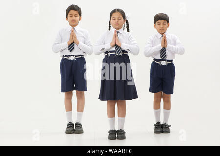 School children praying with hands joined together Stock Photo