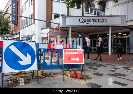 Lavori di manutenzione nella strada di fronte ad un ingresso del Queensmere shopping centre su High Street, Slough, Regno Unito Foto Stock