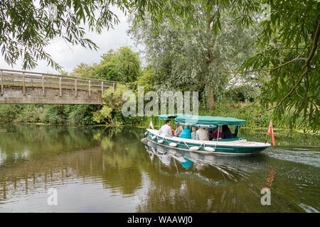 I visitatori di Flatford Mill vai su un viaggio di esplorare in barca sul fiume Stour, Dedham Vale, Suffolk, Inghilterra, Regno Unito Foto Stock