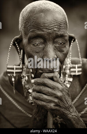 Vecchia donna Masai con tradizionale orecchini pone per un ritratto in Loitoktok, Kenya. Foto Stock