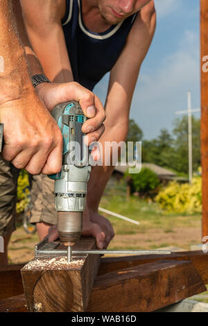 Un falegname punte foro nel legname all giraviti a batteria Foto Stock