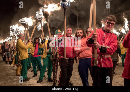 Gli uomini in diversi abiti fantasiosi costumi holding torce di fuoco pongono per la fotocamera al 2019 Up Helly Aa festival a Lerwick, Shetland Foto Stock