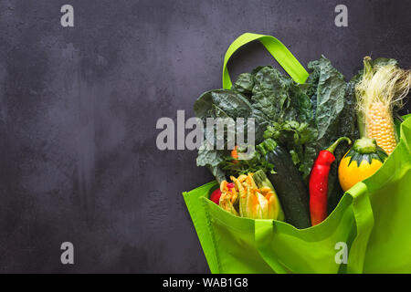 Prodotti freschi dal mercato degli agricoltori in borsa shopping riutilizzabile su rustiche superficie scura. Vista dall'alto, uno spazio vuoto Foto Stock