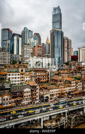 Chongqing Cina, 6 Agosto 2019 : paesaggio urbano verticale dello skyline di Chongqing al crepuscolo con edifici illuminati tra cui la grotta Hongya in Chongq Foto Stock