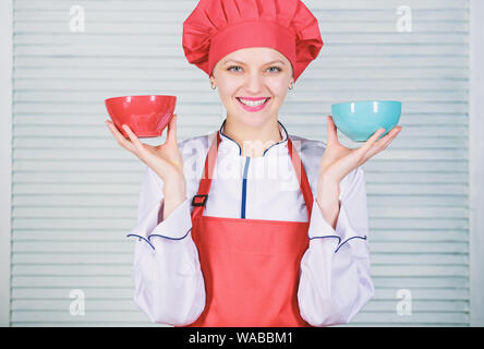 Calcola il tuo cibo porzioni dimensioni. La dieta e dieta concetto. Donna cuocere tenere bocce. Come molte porzioni desiderate mangiare. Calcolare la quantità di calorie si consumano. Calcolare la normale porzione di cibo. Foto Stock