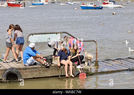 Regno Unito - Previsioni del tempo - Felixstowe Ferry, Suffolk - 19 agosto 2019: luminoso, caldo lunedì pomeriggio nel Suffolk. Bambini attività di pesca del granchio dal molo. Foto Stock