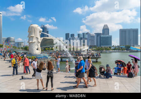 I turisti di fronte alla statua Merlion, simbolo di Singapore, affacciato sulla baia di Marina, Parco Merlion, Singapore, Singapore Foto Stock