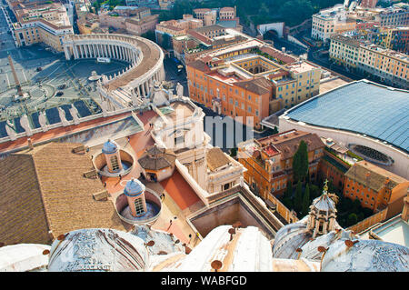 Vista di una parte di Piazza San Pietro (Piazza San Pietro), Obelisco e molte colonne fra molti tetti di colore arancione e piccole torri in Vaticano, Italia. Accogliente c Foto Stock