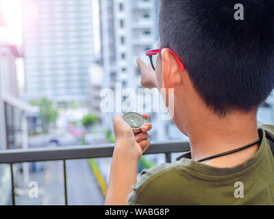 Asia boy bussola di contenimento e rivolto verso il bersaglio. Foto Stock