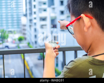 Asia boy bussola di contenimento e rivolto verso il bersaglio. Foto Stock