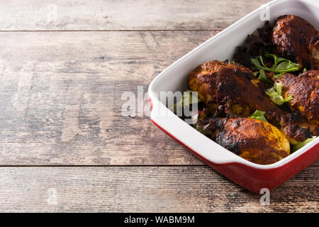 Arrosto di pollo tandoori con riso basmati sul tavolo di legno. Copyspace Foto Stock