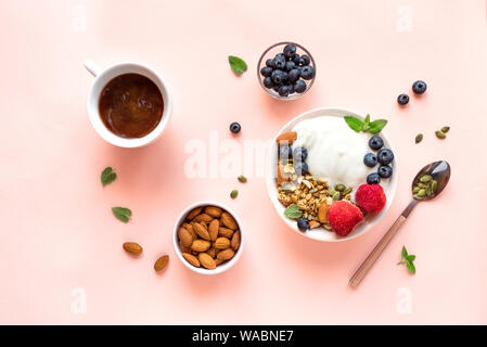 Muesli con yogurt e frutti di bosco per una sana prima colazione. Ciotola di yogurt greco con muesli, mandorle, mirtilli e fragole, vista dall'alto, copia dello spazio. Foto Stock