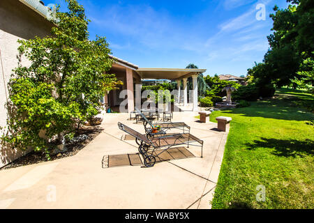 Mobili in ferro battuto sulla moderna casa cortile posteriore Patio Foto Stock
