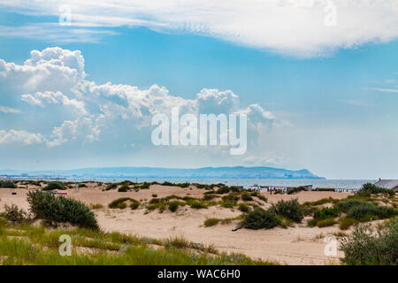 Spiaggia di sabbia con dune di sabbia sul mare contro il cielo blu. Foto Stock