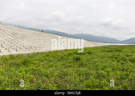 Rikuzentakata, Giappone. 19 Ago, 2019. Un enorme mare muro costruito lungo la costa per proteggere il Takata-Matsubara Memorial Park per il disastro dello tsunami, sotto-costruzione, dove il miracolo pino è conservato come un superstite del 2011 Tsunami. Il memorial park è costruito dal governo del Giappone e il governo della prefettura di Iwate per ricordare le vittime del terremoto del 2011, e come un simbolo di forte volontà per la ricostruzione. Il parco sarà aperto il suo nuovo Grande Oriente Giappone museo dello Tsunami del 22 settembre 2019, e la sua completa di servizi all'inizio del 2021. ''Tohoku Media Tour: Iwate Foto Stock