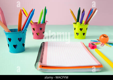 Vista di cubetti multicolori con matite per disegnare sullo sfondo in colori pastello Foto Stock