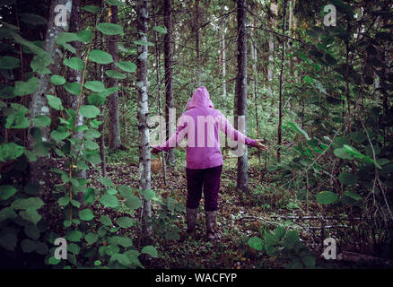 Persona confusa è andato alla raccolta dei funghi e sono andati persi nella foresta, disorientati spaventati e confusi, Nord Europa. Persona persa nel concetto di natura. Foto Stock