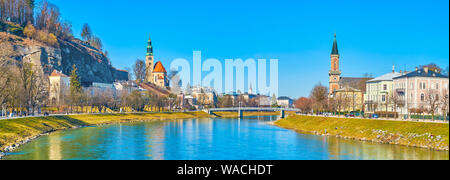 Panorama del fiume Salzach con modesti edifici medievali e alte torri campanarie delle chiese sulle sue rive, Salisburgo, Austria Foto Stock