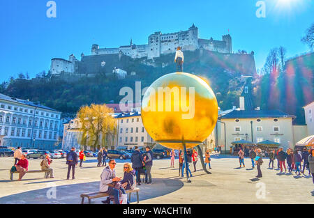 Salisburgo, Austria - 27 febbraio 2019: la vista sulla fortezza di Hohensalzburg, la più importante punto di riferimento della città e il golden Sphaera in Kapitelplat Foto Stock