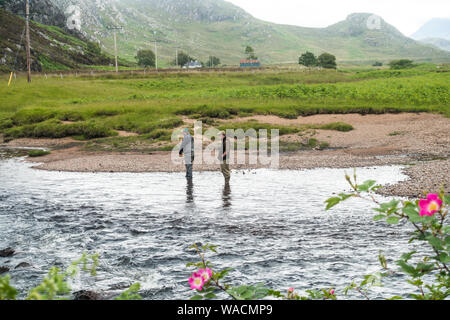 Salmone pesca pescatore il fiume Gruinard con Gillie nella visione, Gruinard, Wester Ross, Scotland, Regno Unito. Foto Stock