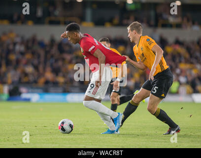 19 agosto 2019; Molineux Stadium, Wolverhampton, West Midlands, Inghilterra; Premier League inglese, Wolverhampton Wanderers contro Manchester United e Ryan Bennett di Wolverhampton Wanderers si tira indietro sulla maglietta di Anthony Martial del Manchester United come egli si rompe in avanti con la palla è ai suoi piedi - rigorosamente solo uso editoriale. Nessun uso non autorizzato di audio, video, dati, calendari, club/campionato loghi o 'live' servizi. Online in corrispondenza uso limitato a 120 immagini, nessun video emulazione. Nessun uso in scommesse, giochi o un singolo giocatore/club/league pubblicazioni Foto Stock