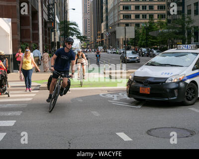 Ciclista evitando taxi. Chicago, Illinois. Foto Stock